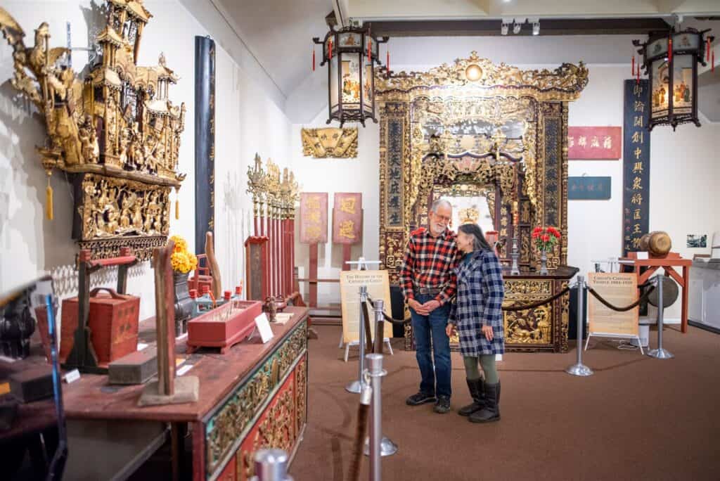A man and a woman looking at a Chinese artifacts display