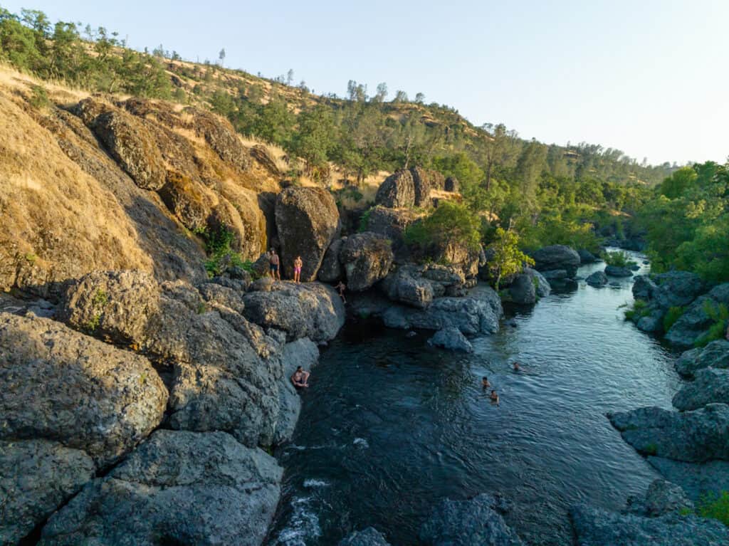 Late afternoon at Upper Bidwell Park's Bear Hole, with people hanging out on the rocks and swimming in the water