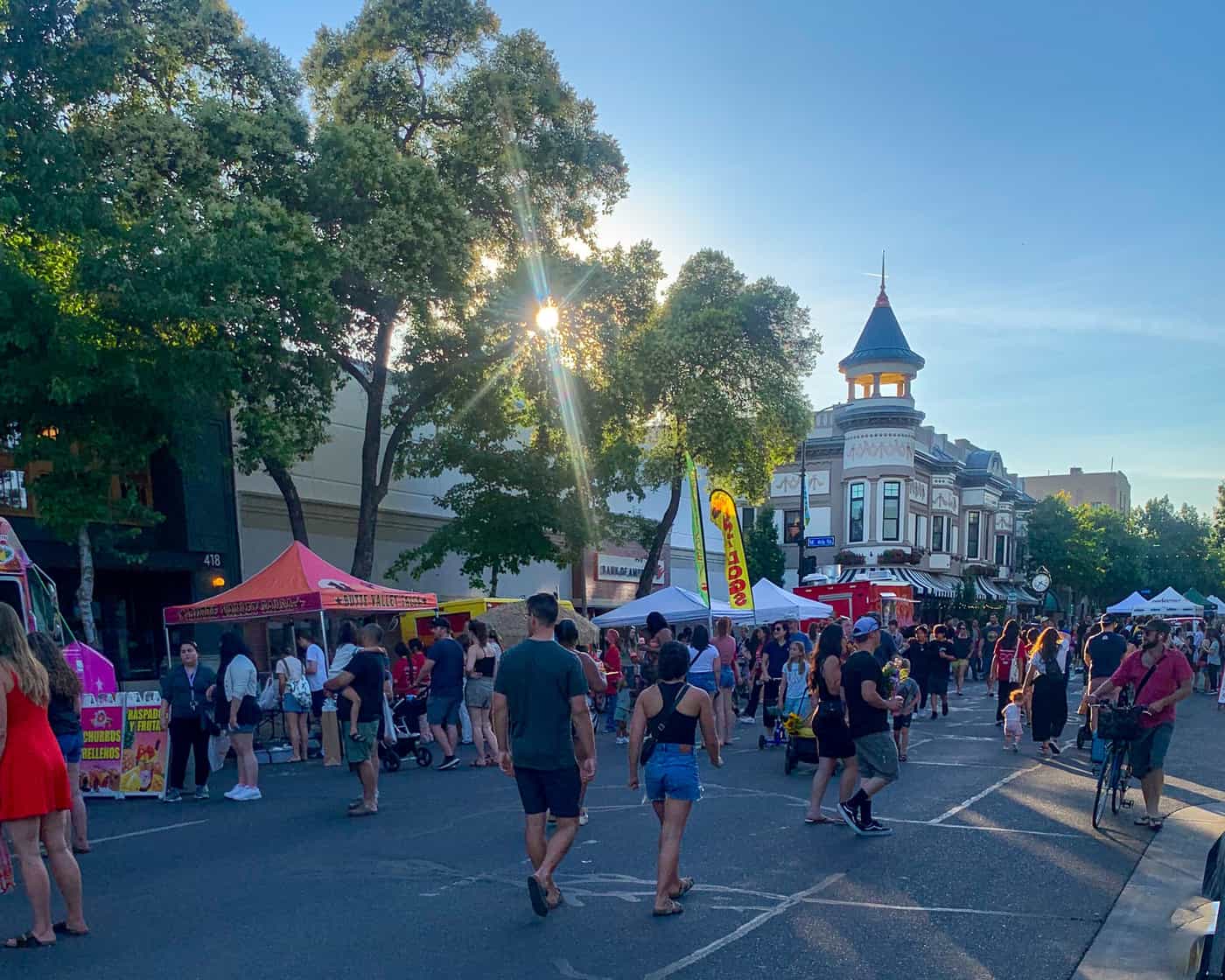 People walk on Broadway Street among pop-up tents during Thursday Night Market in Downtown Chico