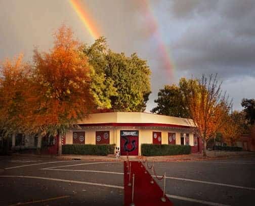 Exterior of the Pageant Theatre in the fall with a double rainbow in the background
