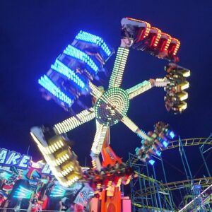 A neon-lighted spinning ride at night at Silver Dollar Fair