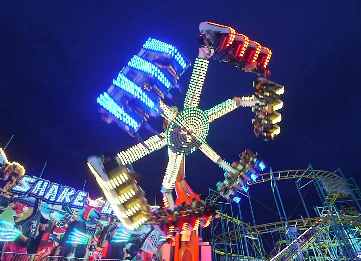 A neon-lighted spinning ride at night at Silver Dollar Fair