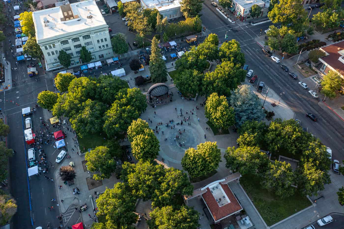 Aerial view of a people-filled Chico City Plaza surrounded by trees and buildings