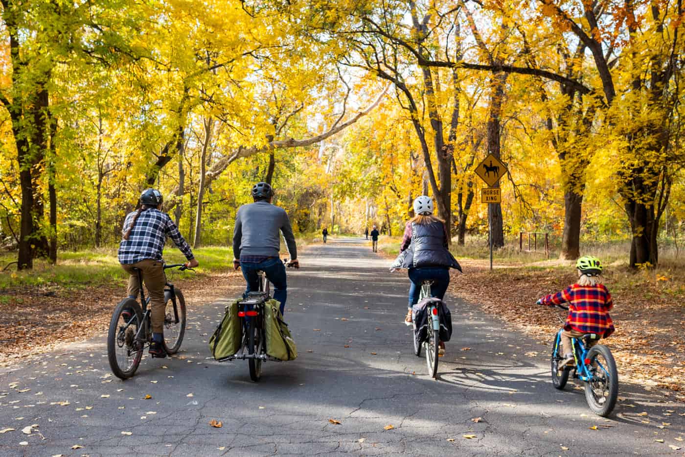 A family of four riding bikes through Lower Bidwell Park in the fall