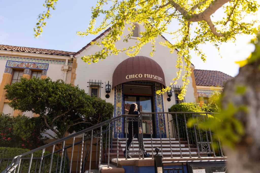 A woman walks up the stairs to the entrance of the Chico History Museum