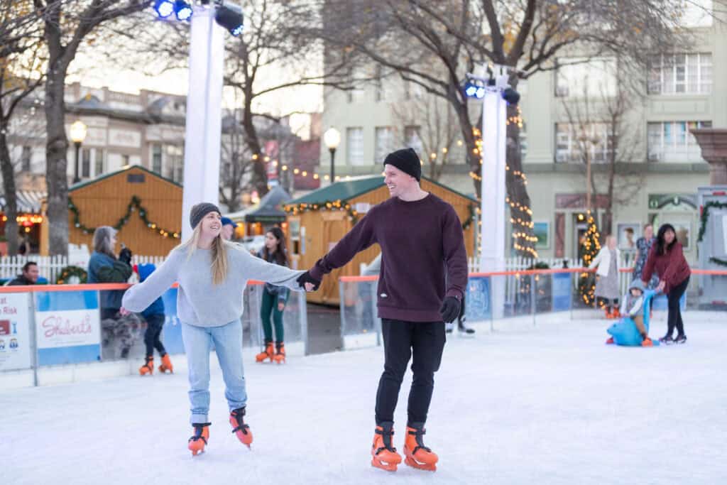 A couple ice skating hand-in-hand during a visit to Chico in the winter